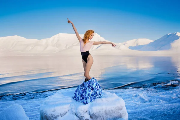 Chica delgada hermoso pelo rojo en un cuerpo en la helada sobre un fondo de montañas svalbard en la ciudad de Spitsbergen Longyearbyen — Foto de Stock