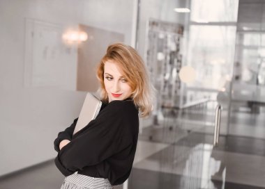 Kız genç güzel sarışın hipster siyah bluz içinde içinde kırmızı dudaklar ile akıllı laptop tablet kullanarak tutar