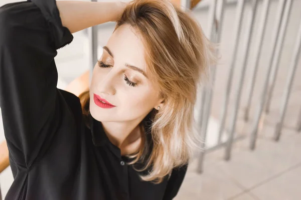 Girl young beautiful blonde hipster with red lips expressive eyes inside posing