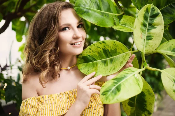 Retrato de cerca de la joven hermosa chica con pelo rizado vestido de verano amarillo en el bosque tropical —  Fotos de Stock