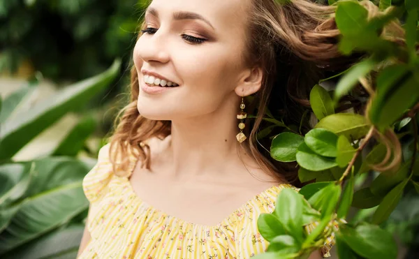 Retrato de cerca de la joven hermosa chica con pelo rizado vestido de verano amarillo en el bosque tropical —  Fotos de Stock