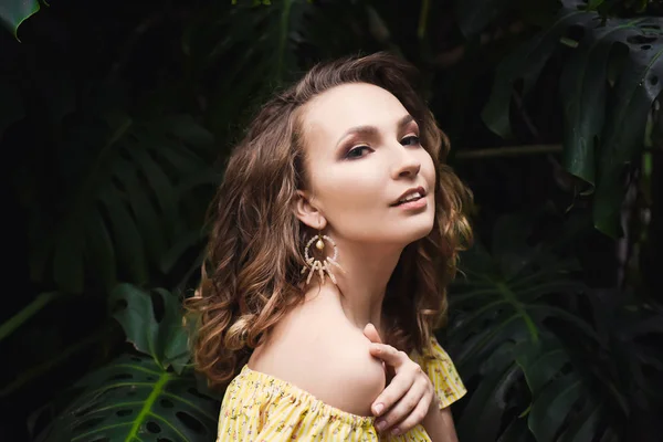 Ritratto ravvicinato di giovane bella ragazza con capelli ricci vestito estivo giallo nella foresta tropicale — Foto Stock