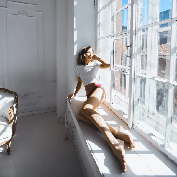 Mujer sentada en un alféizar de ventana —  Fotos de Stock