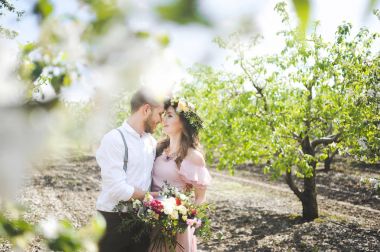 iki kız ve bir düğün için arayan adam, başında bir arka plan Bahçe ve mavi gökyüzü, çiçek çelenk ile uçan bir pembe elbise elbise ve onlar sarılmak
