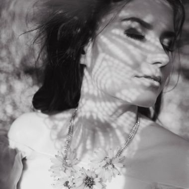 Kız bir gelinlik için sarılmak ve poz başında bir arka plan Bahçe ve mavi gökyüzü ve onlar çiçek çelenk ile uçan pembe elbise 