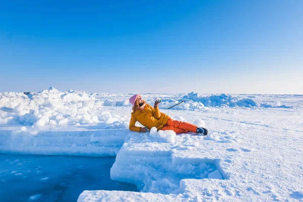 Ragazza in un piumino giallo rosa cappello a maglia con i capelli rossi bei capelli giovani in un hoarfrost sullo sfondo del campo Barneo su un polo nord innevato in inverno — Foto Stock