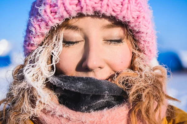 Menina em uma jaqueta amarela rosa gorro de malha com cabelo vermelho belo cabelo jovem em uma geada no fundo do acampamento Barneo em um pólo norte nevado no inverno — Fotografia de Stock