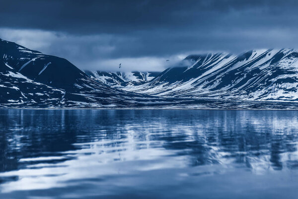landscape of the Arctic Ocean and reflection with blue sky and winter mountains  Norway, Spitsbergen, Longyearbyen, Svalbard