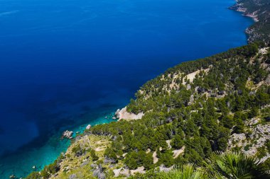 Güzel bir mavi gökyüzü ve taşlı kayalar yakınındaki masmavi deniz güneşli bir günde Mallorca İspanya'nın peyzaj seyahat