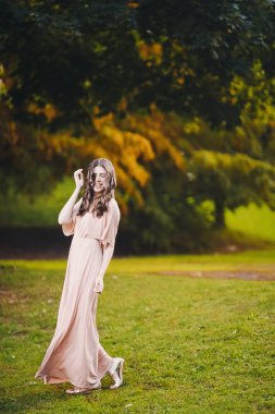 uzun elbise çiçeklere günbatımı yaşam tarzı yeşil bir park yürürken ince bir genç esmer kızla güzel çekici Bayan