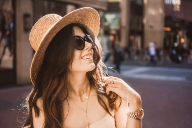  bir ince genç kız blogger portresi şehir merkezinde güzel esmer dusseldorf pastel elbise ve bir bayanın şapka giyen yürüyüş pozlar ve günbatımı üzerinde gülümseyen güneş gözlüğü
