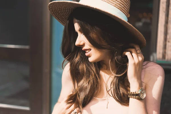 Retrato de una delgada joven blogger hermosa morena en el centro de Dusseldorf con un vestido de pastel y un sombrero de señora con gafas de sol caminando poses y sonriendo en la puesta de sol — Foto de Stock