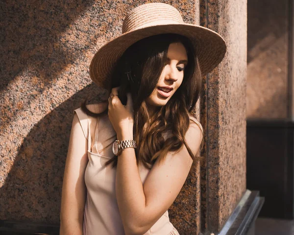 Πορτρέτο ενός blogger λεπτή νεαρή κοπέλα όμορφη μελαχρινή στο κέντρο του Ντίσελντορφ σε μια παστέλ φόρεμα και μιας κυρίας καπέλο φοράει γυαλιά ηλίου περπάτημα πόζες και χαμογελαστά για το ηλιοβασίλεμα — Φωτογραφία Αρχείου