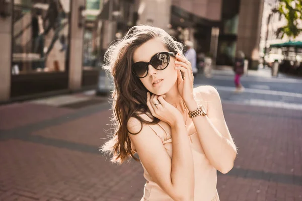 Portret blogger szczupła dziewczyna Młoda piękna brunetka w centrum miasta Düsseldorf w pastelowe sukienki i Pani na sobie okulary spaceru pozach i uśmiecha się na zachód słońca — Zdjęcie stockowe
