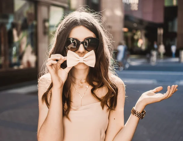 Porträt einer schlanken jungen Bloggerin schöne Brünette in der Düsseldorfer Innenstadt in einem pastellfarbenen Kleid und einer Dame mit Sonnenbrille, die im Sonnenuntergang posiert und lächelt — Stockfoto