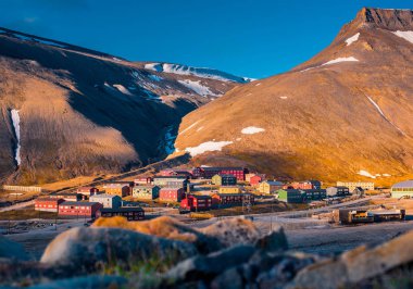 Günbatımında Arktik yaz polar bir gün Spitzbergen'deki Longyearbyen Svalbard bina şehir dağ doğa manzara 