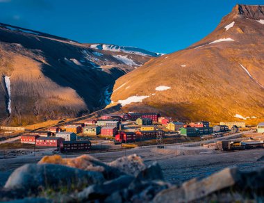 landscape nature of the mountains of Spitzbergen Longyearbyen Svalbard building city on a polar day with arctic summer in the sunset  clipart