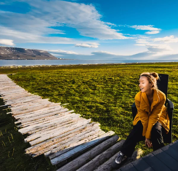 Portré Norvégia táj jellege a hegyek a Spitzbergák Longyearbyen, Svalbard lány mosolyogva lyifestyle a polar nap sarkvidéki nyáron a naplemente és kék, cloudly égen sárga kabát — Stock Fotó