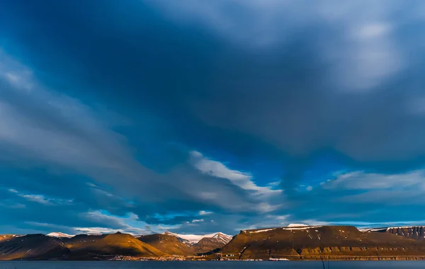 雲と夕焼けと青空に夏の北極の極地の日にスピッツ ベルゲン ロングヤービーエンのスヴァールバル諸島の建物都市の山のノルウェーの風景自然を壁紙します。 — ストック写真