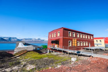 Landscape of the Russian  city of Barentsburg on the Spitsbergen archipelago in the summer in the Arctic In sunny weather and blue sky clipart