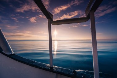 Deniz okyanus dalgalarının Svalbard Spitsbergen adalar Longyearbyen kıyısında pembe turuncu günbatımı manzara