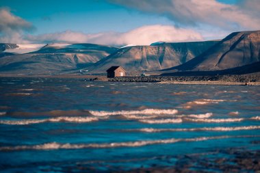 Bir doğa Norveç city Longyearbyen yakınındaki Spitsbergen Svalbard dağlarında bulutlu pembe bir günbatımı manzara
