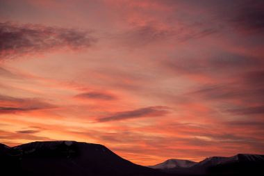 Gün batımı gün doğumu bulutlu Norveç city Longyearbyen yakınındaki Spitsbergen Svalbard dağlarında bir doğa manzara seyahat etmek