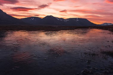 Gün batımı gün doğumu bulutlu Norveç city Longyearbyen yakınındaki Spitsbergen Svalbard dağlarında bir doğa manzara seyahat etmek