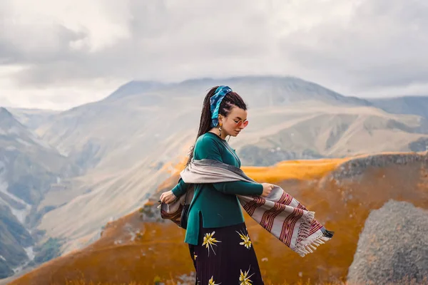 saç dreadlock bulutlu gökyüzü arka plan ve dans Gürcistan sonbahar dağlar bir boho çingene hippi tarzı giysili bir genç güzel hipster kızla güneş gözlüğü portresi