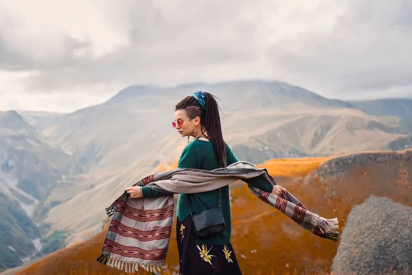 saç dreadlock bulutlu gökyüzü arka plan ve dans Gürcistan sonbahar dağlar bir boho çingene hippi tarzı giysili bir genç güzel hipster kızla güneş gözlüğü portresi