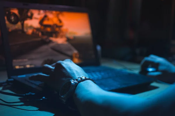 Pria kecanduan close-up dengan tangan jantan bermain video game di layar komputer dengan jari di keyboard Stok Gambar Bebas Royalti