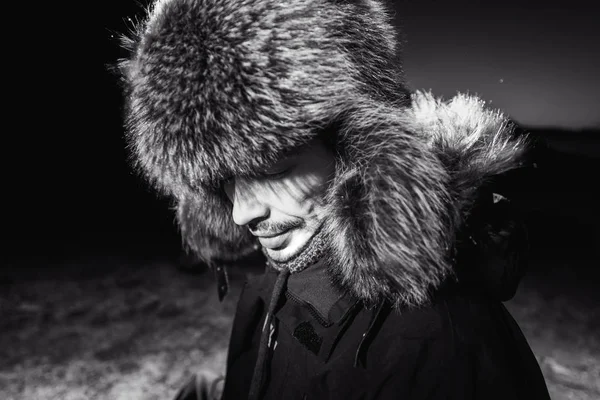 Homem com uma barba vestindo um chapéu de pele de guaxinim explorador polar um brutal forte viril no fundo natureza da montanha Svalbard Longyearbyen Svalbard Noruega — Fotografia de Stock