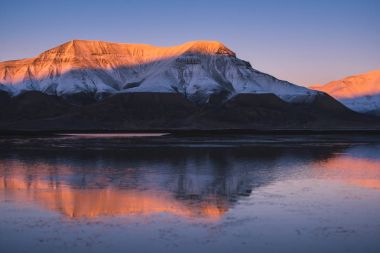 Doğada Spitsbergen Svalbard yansıma okyanus Dağları Norveç şehir Longyearbyen yakınında bir pembe günbatımı manzara