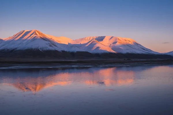 Landschap van aard van een roze zonsondergang in de bergen van de reflectie-Oceaan van Spitsbergen Svalbard in de buurt van de Noorse stad Longyearbyen — Stockfoto