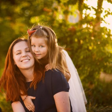 genç güzel kızıl saçlı annesi ve kız kardeşi gülümseyen sevimli kızı olan güneşli bir günde, aile portre kucakladı