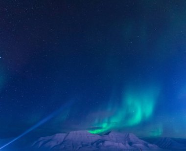 The polar arctic Northern lights aurora borealis sky star in Norway Svalbard in Longyearbyen city the moon mountains clipart
