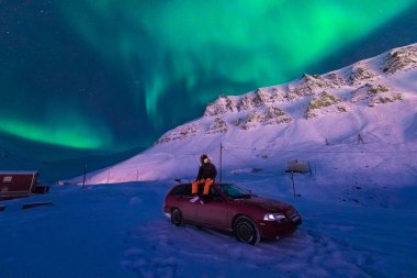 Kutup kutup kuzey ışıkları aurora borealis gökyüzü ay Dağları Longyearbyen City'de Norveç Svalbard adamla içinde yıldız