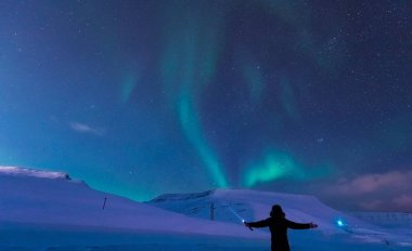 Kutup kutup kuzey ışıkları aurora borealis gökyüzü ay Dağları Longyearbyen City'de Norveç Svalbard adamla içinde yıldız