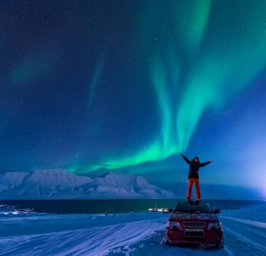 Kutup kutup kuzey ışıkları aurora borealis gökyüzü ay Dağları Longyearbyen City'de Norveç Svalbard adamla içinde yıldız