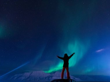 Kutup kutup kuzey ışıkları aurora borealis gökyüzü ay Dağları Longyearbyen City'de Norveç Svalbard adamla içinde yıldız