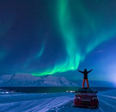 Kutup kutup kuzey ışıkları aurora borealis gökyüzü ay Dağları Longyearbyen City'de Norveç Svalbard adamla içinde yıldız