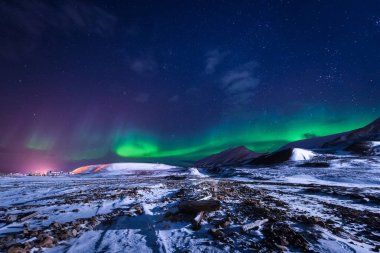 The polar arctic Northern lights aurora borealis sky star in Norway Svalbard in Longyearbyen city town mountains clipart