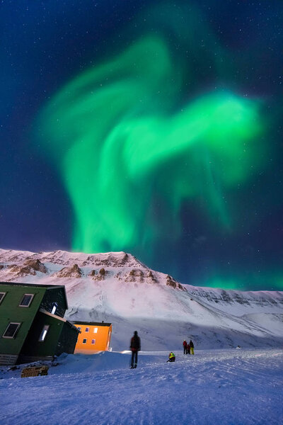 The polar arctic Northern lights aurora borealis sky star in Norway Svalbard in Longyearbyen city man mountains