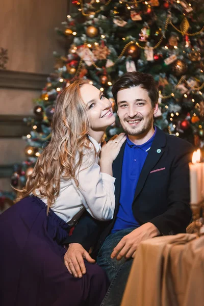 背景に彼女のボーイフレンドの美しい若いブロンドの女の子のカップルメリークリスマス星のギフトの装飾と幸せな新年の木のライト ファミリー シューティング — ストック写真