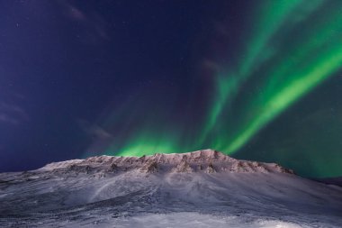 Kuzey kutup ışıkları aurora borealis gökyüzü yıldızı Norveç 'te Svalbard, Longyearbyen' de dağlarla birlikte. Seyahat macerası