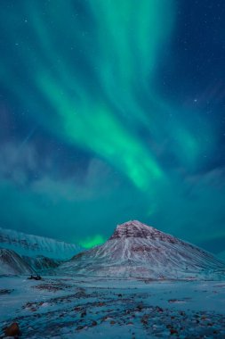 Kuzey kutup ışıkları aurora borealis gökyüzü yıldızı Norveç 'te Svalbard, Longyearbyen' de dağlarla birlikte. Seyahat macerası
