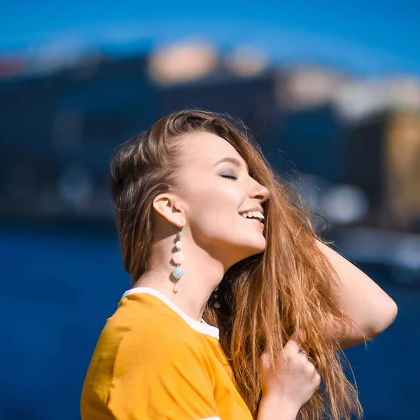 在圣彼得堡市的背景下 一个年轻的嬉皮士美女 穿着蓝色裙子笑着摆姿势的年轻姑娘的特写 — 图库照片