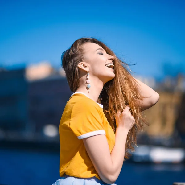 치마를 웃으며 상트페테르부르크 배경에 포즈를 취하는 아름다운 금발의 소녀의 근접촬영 — 스톡 사진