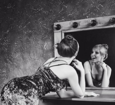 Moda stüdyosunun yakın plan bir portresi. Genç, zayıf, seksi, seksi, kostüm giymiş, Tinker Bell saçlı, gülümseyen ve poz veren bir kız.