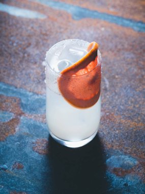 Beyaz roily kokteyl pürüzsüz bir şeffaf cam buz küpleri ile taze greyfurt paslı bir arka plan üzerinde sağ parçası ile dekore edilmiştir. Arka ışık, dikey yönlendirmesi, metin alanı